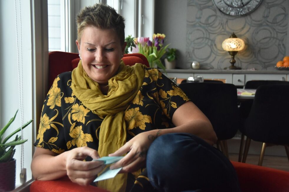 SELVIRONI. Hilde Solvoll Øzkan (48) ler av seg selv mens hun titter gjennom huskelappene hun har skrevet før intervjuet. I tillegg har hun gjerne huskelapper til alt annet hun gjør, ettersom korttidshukommelsen er hardt svekket etter behandlingen. Foto: Victoria Finstad