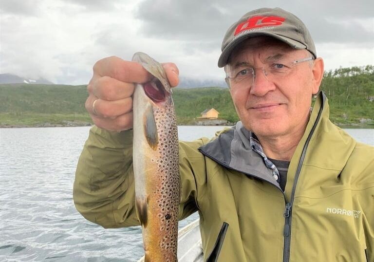 FIKS FANGST. Ole Petter Nybakk er glad i å fiske. Her har kona tatt bilde av en fornøyd kar som nettopp har lurt om bord en lekker ørret.
 Foto: Marit Nybakk