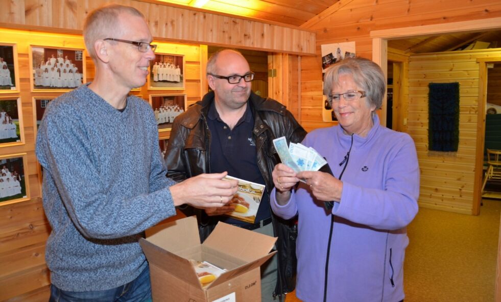 STORHANDEL. Marianne Beck sikret seg fire kokebøker på lanseringsdagen. Her sammen med kirkeverge Sigmund Gulliksrud (t.v.) og fotograf Bjørn Fridtjofsen. Nå er hele opplaget på 600 solgt. Arkivfoto: Sverre Breivik