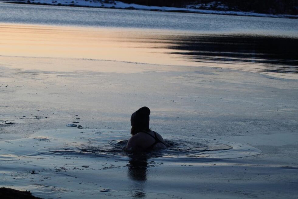 I VANNET. Her er Tine Fure godt nedi den kalde sjøen, som har en tyunn isskorpe på overflaten. En iskald opplevelse som skal være oppkvikkende og sunn for kroppen.
 Foto: Monica Johansen